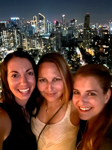 A selfie with three women in front of a cityscape in Iceland