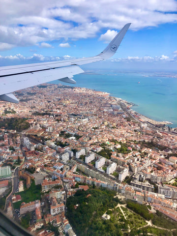 Wingtip flying over Lisbon, brick colored rooftops and Atlantic ocean