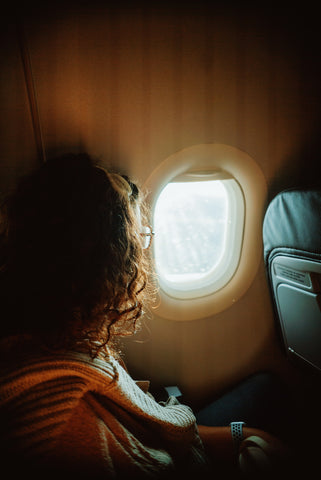 A woman on a plane looking out the window