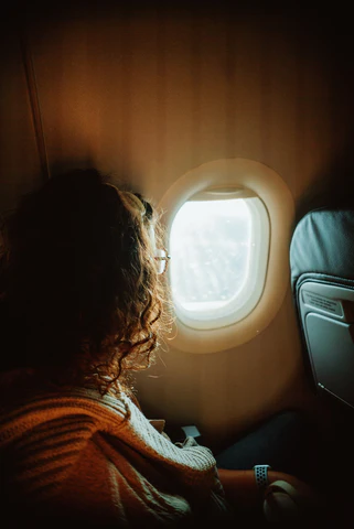 A woman on a plane looking out the window