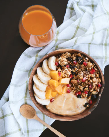 An abundance breakfast of fruit, granola, yogurt and juice