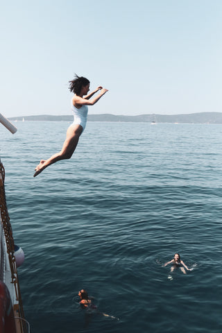 A woman jumping off a boat into the sea