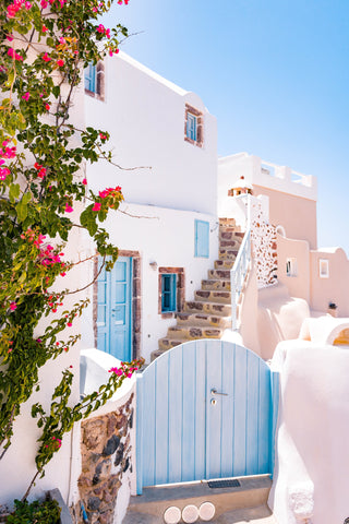 A beautiful patio in Greece with blue rooftops and pink flowers