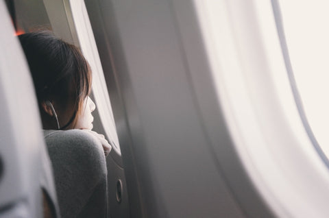 A woman looking out the window of a plane