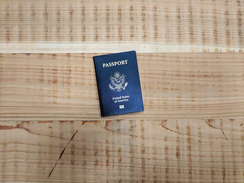 A US passport against a light-colored wooden background