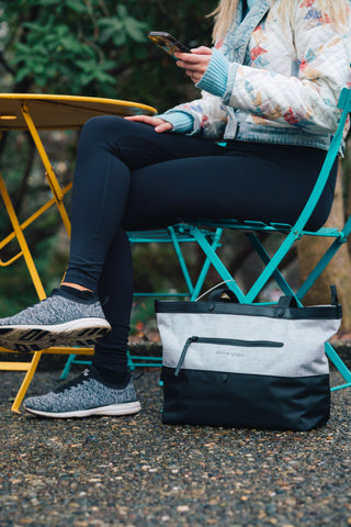 Sherpani's Anti-Theft bag, the Cali, sitting by a woman's legs at an outdoor table