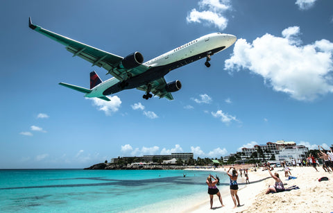 An incoming plane flys low over Maho Beach in Sint Maarten