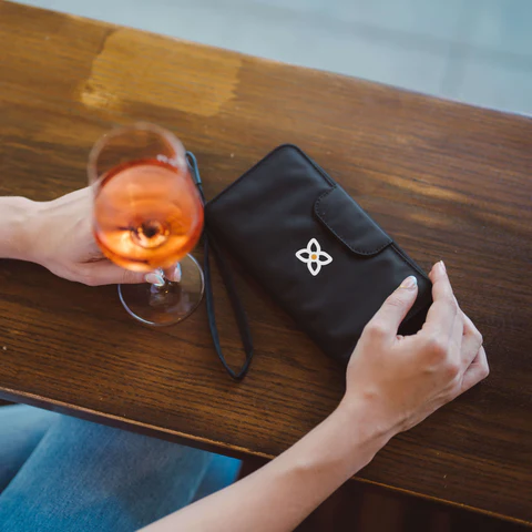 The Tulum RFID wallet sitting on a table next to a cocktail