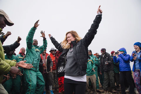 A dancing woman with her hands in the air and her eyes closed