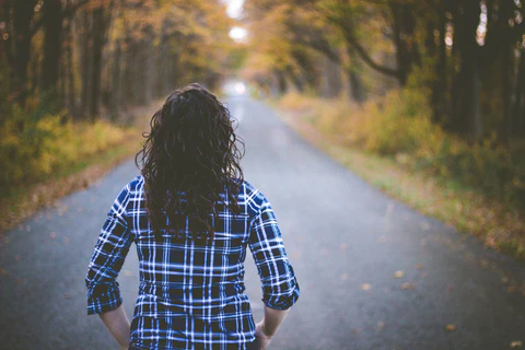 Woman wearing flannel among fall leaves