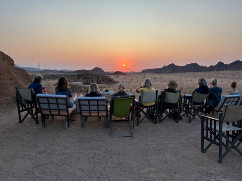 A group of women on a Girl's Guide tour in Namibia watching the sunset together