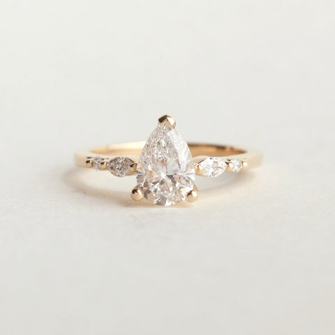 A dainty, 5-stone diamond engagement ring, featuring a pear-cut lab-grown diamond centre, and accented with marquise and round natural diamonds. The Delphine is modern, feminine, and not one you'll likely be able to forget.