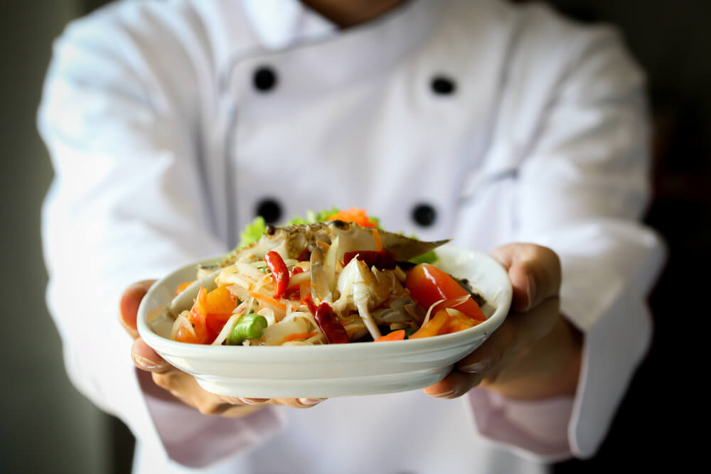 Chef proudly presenting Thai spicy crab papaya salad