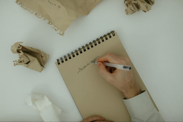 man scribbling out mistake on paper