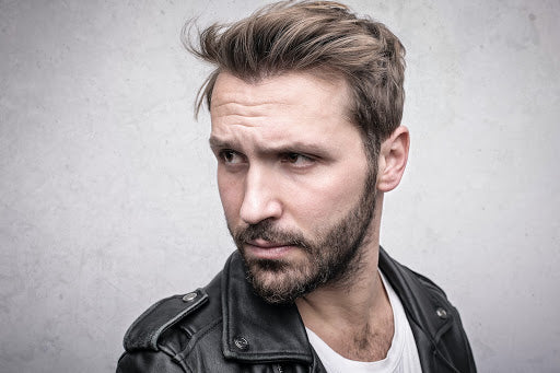 Man with short-medium length hair in white t-shirt and leather jacket looking off camera | Style Standard
