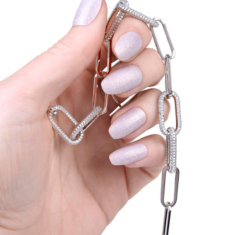 RiseShed Linked Chain Necklace is being held in hand with pink painted manicured nails