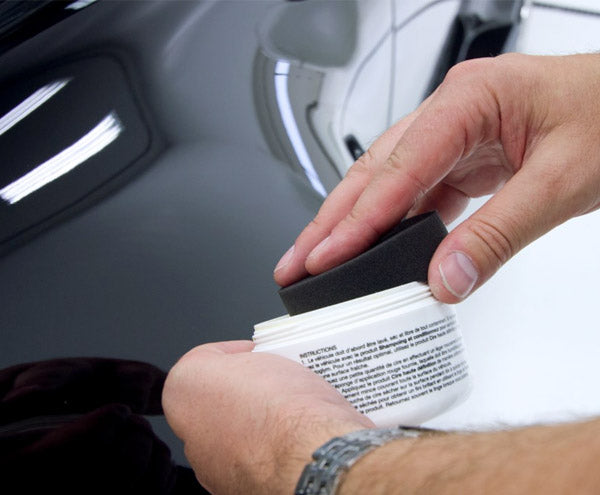 Round foam applicator being used with car wax