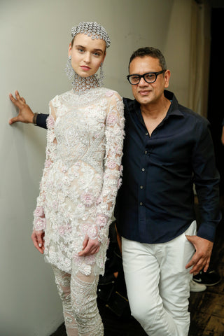 Naeem Khan with model dressed in new collection backstage at catwalk show.