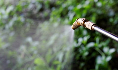 Sprayer applying water and fertilizer to a garden