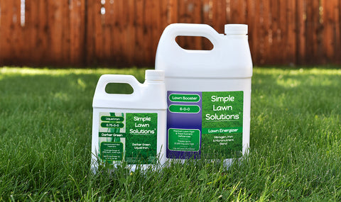 Two Simple Lawn Solutions liquid lawn fertilizers resting on a dark green lawn