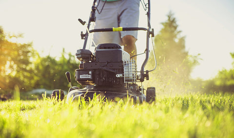 Man mowing a lawn in the hot summer