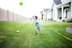 Boy playing with a ball in his yard