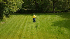 Man mowing large lawn with a push mower