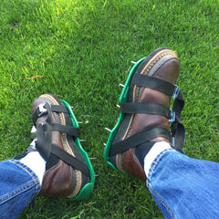 Person Wearing Aerating Spike Shoes on Green Grass