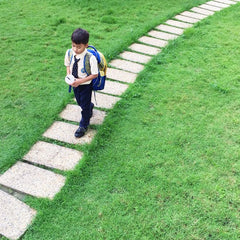 Kid walking on stones in grass