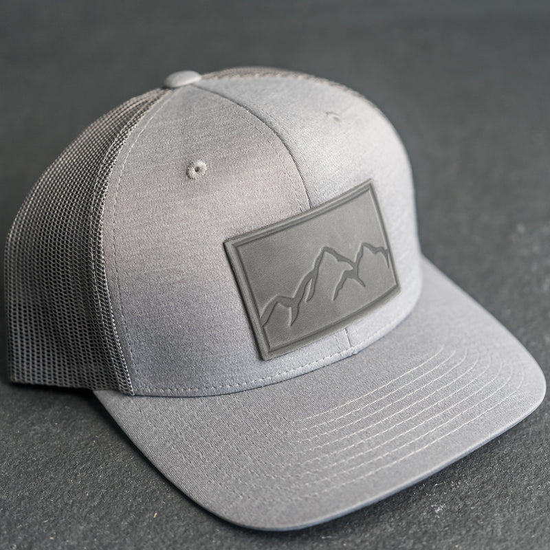 Leather Patch Performance Style Trucker Hat - Mountain Range Stamp