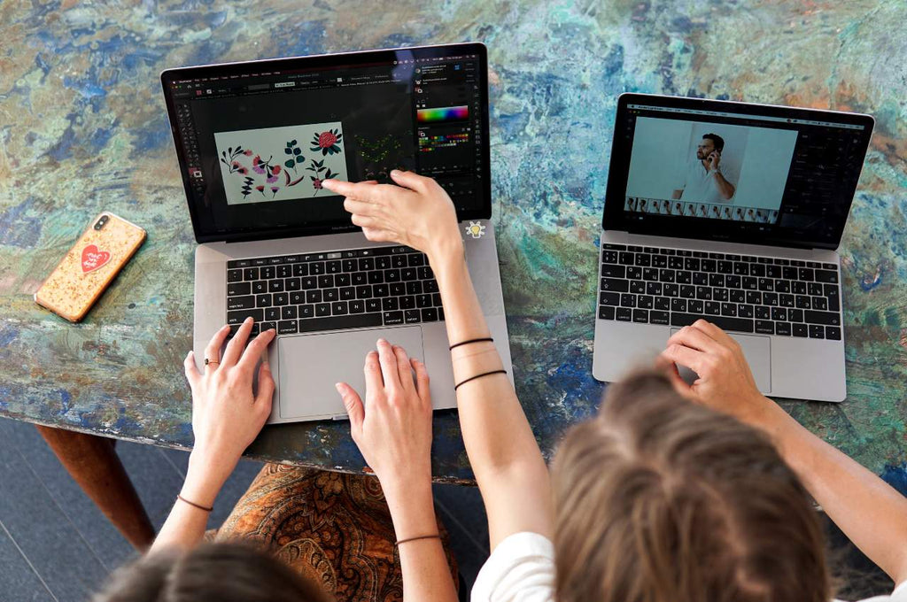 two ladies editing photos on their laptops