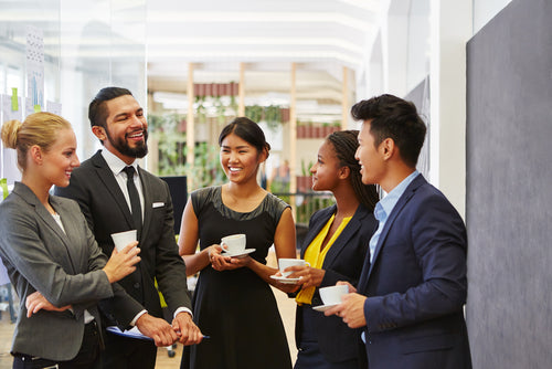 People gathering around drinking coffee in an office setting