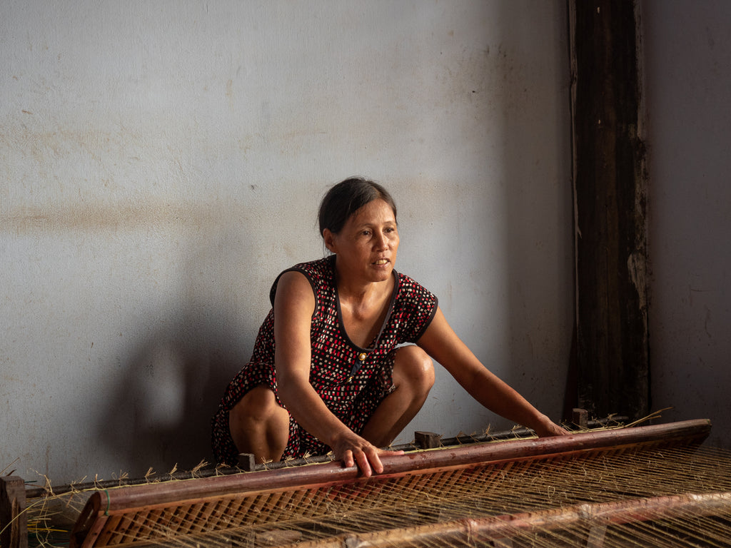Vietnamese woman weaving a sleeping mat