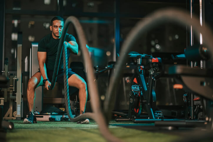 man working out with ropes