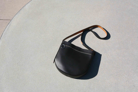 FERAL halfmoon leather handbag