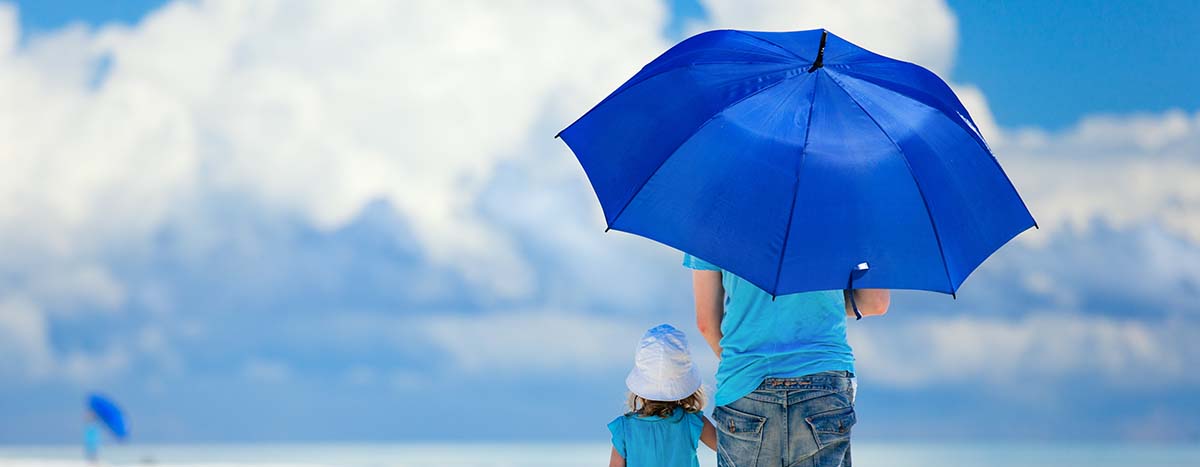 Person and child holding umbrella in sun