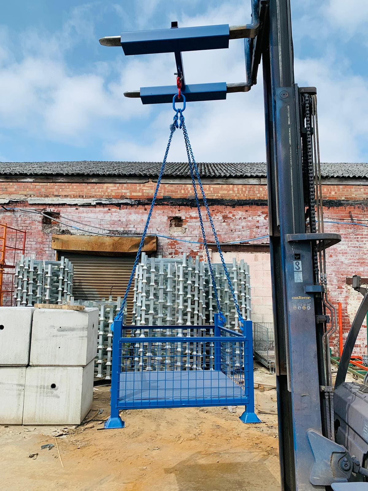 Image of mesh pallet cage being lifted by forklift crane