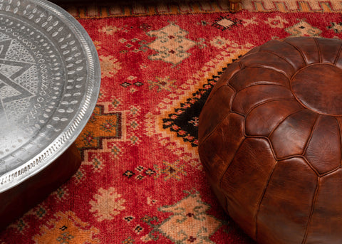 Marockansk sittpuff på en fin ullmatta från marocko i vardagsrummet hos zahara vintage