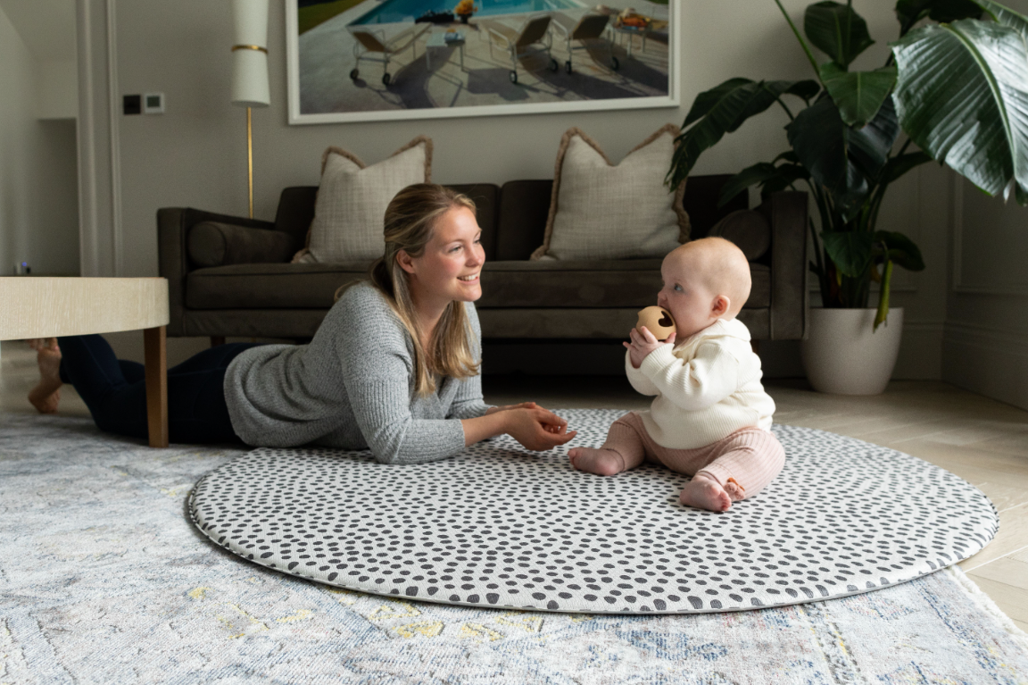 Mum and baby on Round Scout design play mat by Totter + Tumble