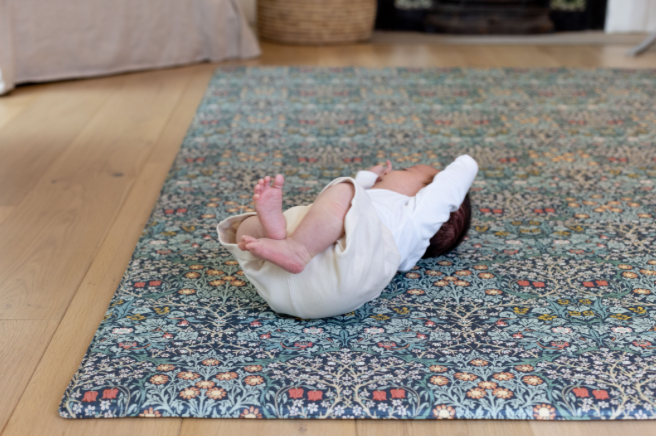 Baby playing on the Blackthorn Morris & co. collection play mat