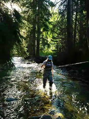 Woman Fly Fishing Angler wading in mountain river