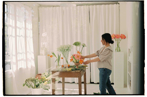 mujer con flores en su taller 