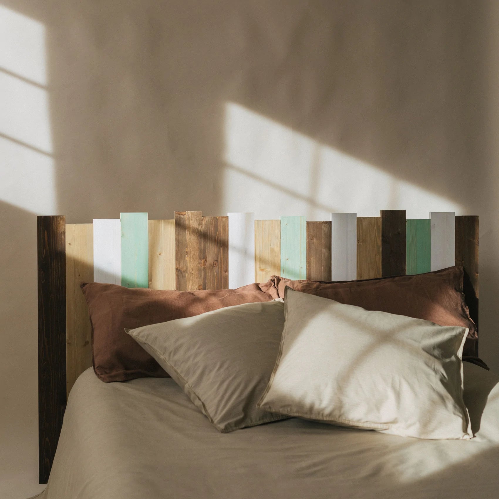 Cabecero de cama de madera con listones de colores.