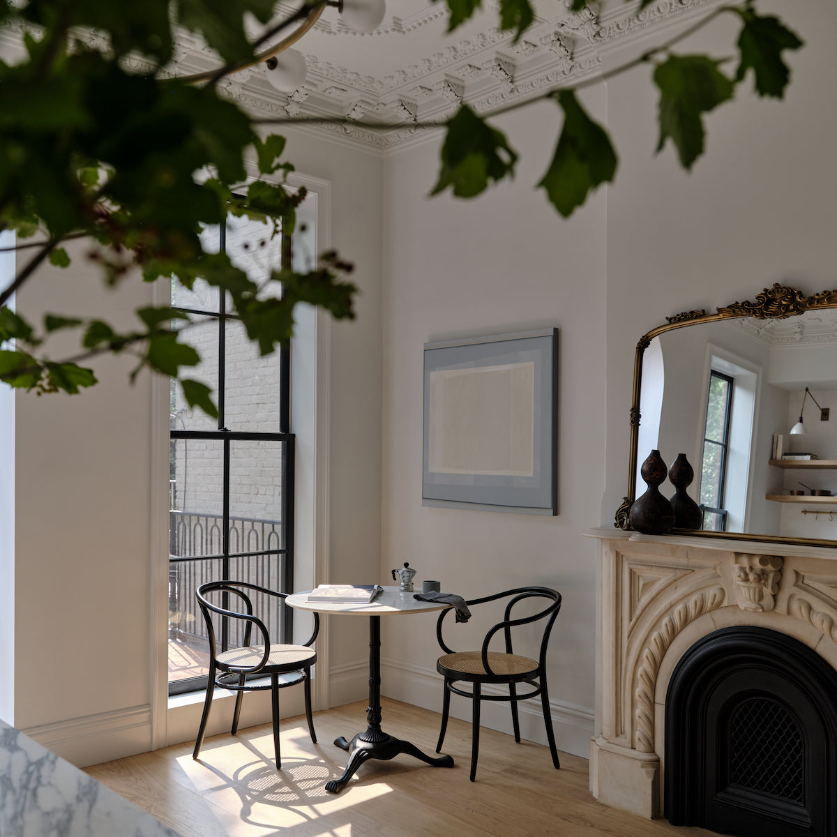 A brownstone breakfast nook with a marble fireplace and white oak flooring