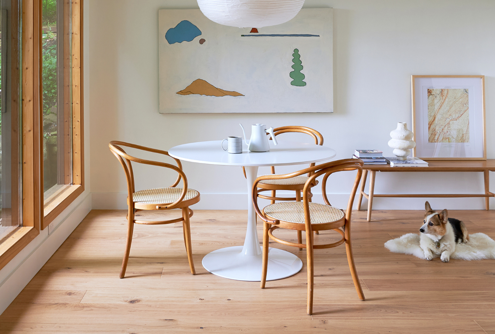 Scandinavian design tulip table and Thonet chairs with white oak flooring in a basement