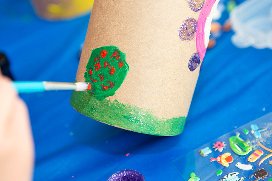 Painting a colorful bush on cardboard tube for a DIY bug hotel project