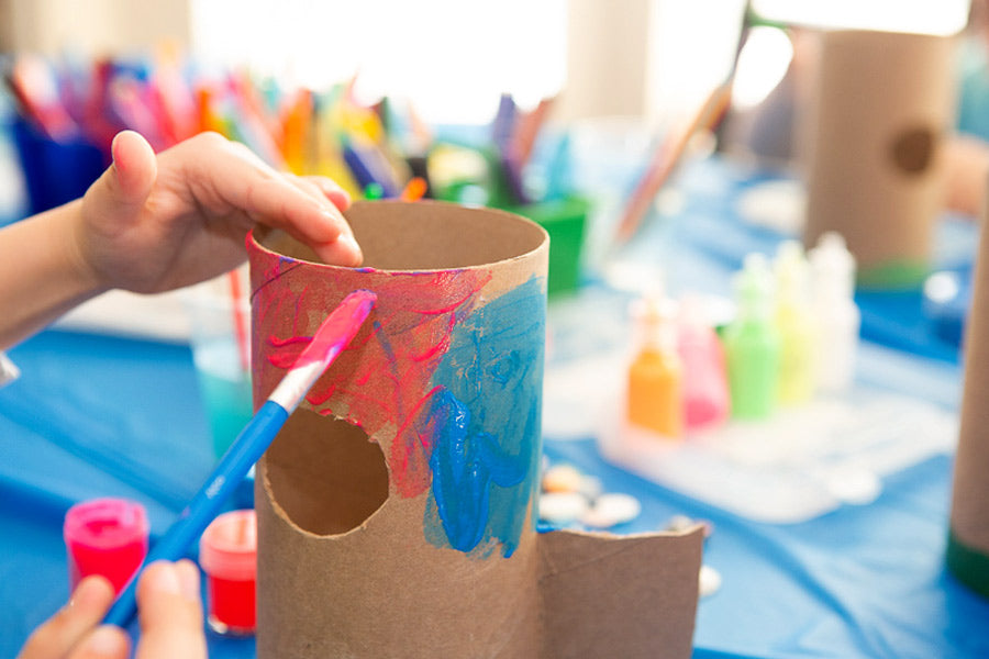 Kid decorating a cardboard tube for a DIY bug hotel craft