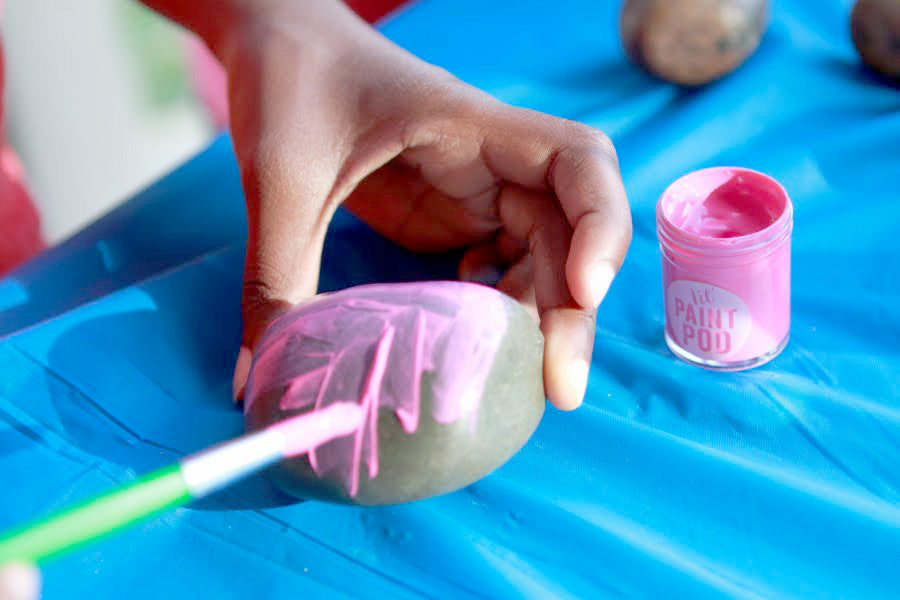 Photo of kid painting rock with pink lil Paint Pod Poster Paint