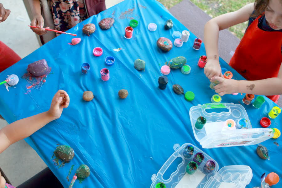 Kids painting rocks with poster paints from OOLY