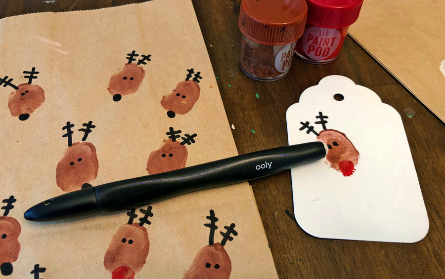 Adding details like antlers and noses to the DIY holiday gift bags